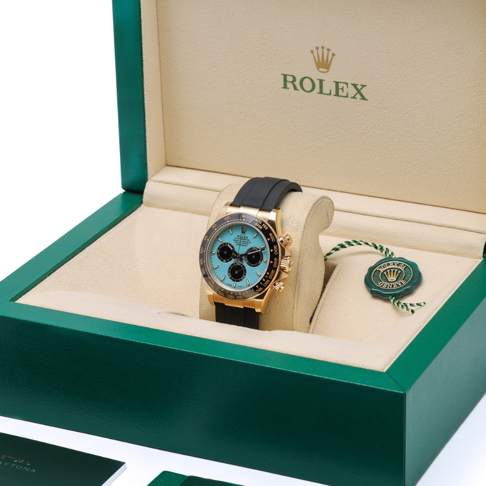 Chronograph, gold case, black bezel, turquoise dial with black sub-dials, black rubber strap